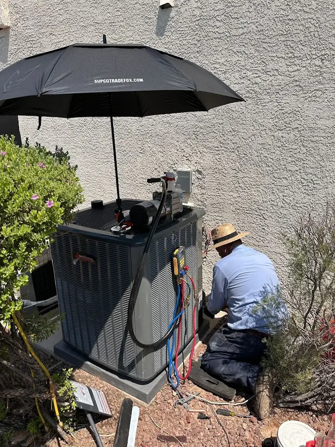 HVAC technician performing outdoor AC maintenance in Brighton